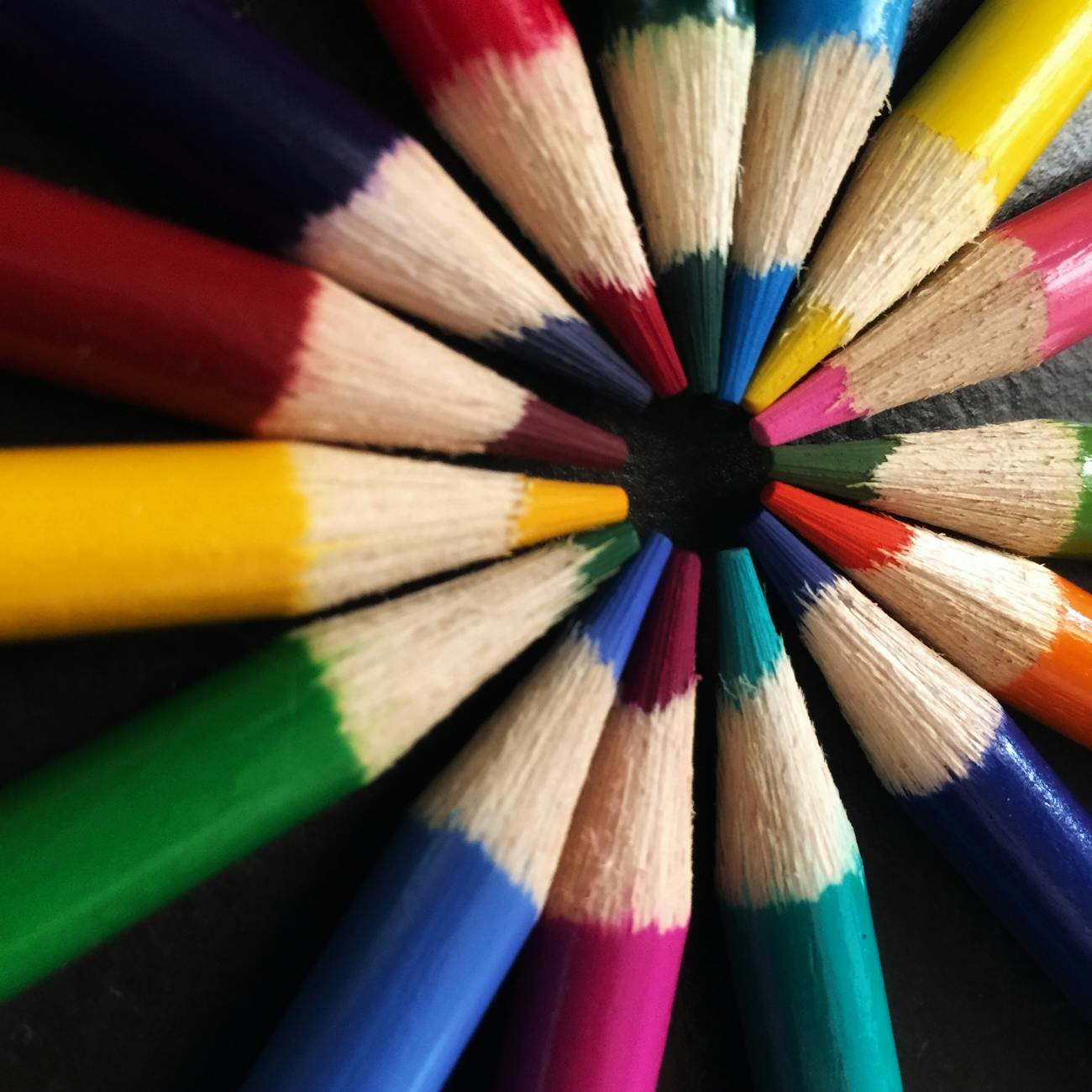 colorful colored pencils arranged in a circle with the tips pointing inward
