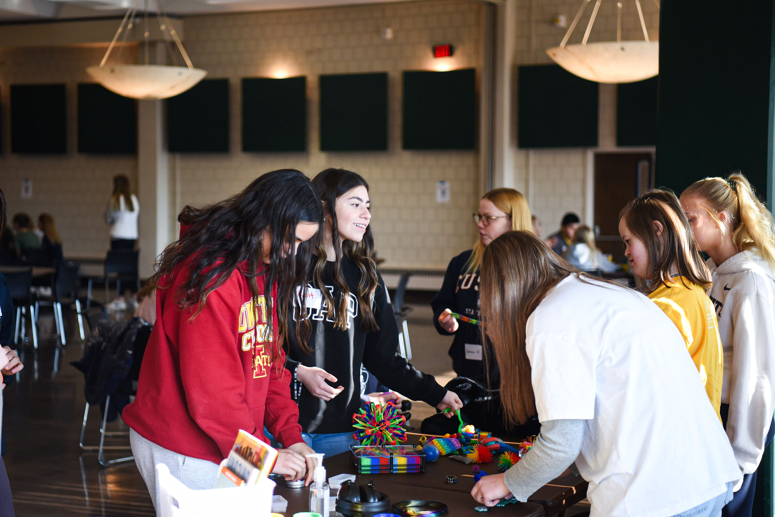 Youth stand around and interact with a table of sensory items